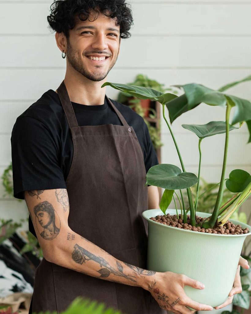small-business-owner-holding-a-potted-plant-at-the-2022-04-12-03-01-23-utc.jpg
